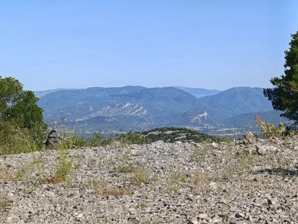 Plateau rocailleux au premier plan, avec les Cévennes en arrière-plan sous un ciel dégagé.