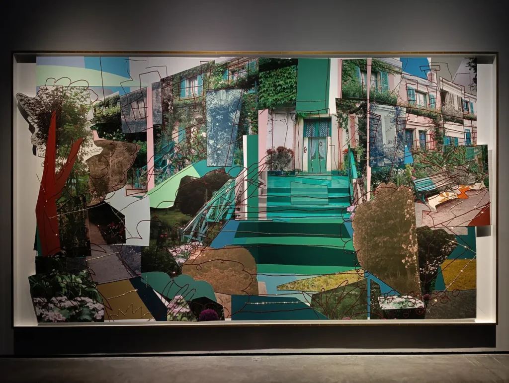 Photo d'une œuvre d'art contemporain représentant un paysage urbain fragmenté, mêlant bâtiments, végétation luxuriante et éléments géométriques colorés. L’œuvre s'intitule la maison de Monet.
