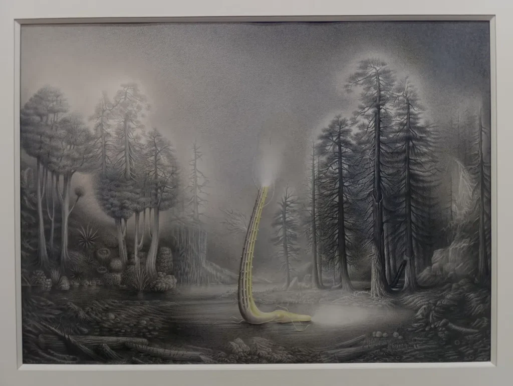 Photo d'un dessin encadré en noir et blanc représentant une créature fantastique légèrement colorée dans une forêt brumeuse, avec des arbres détaillés en arrière-plan.