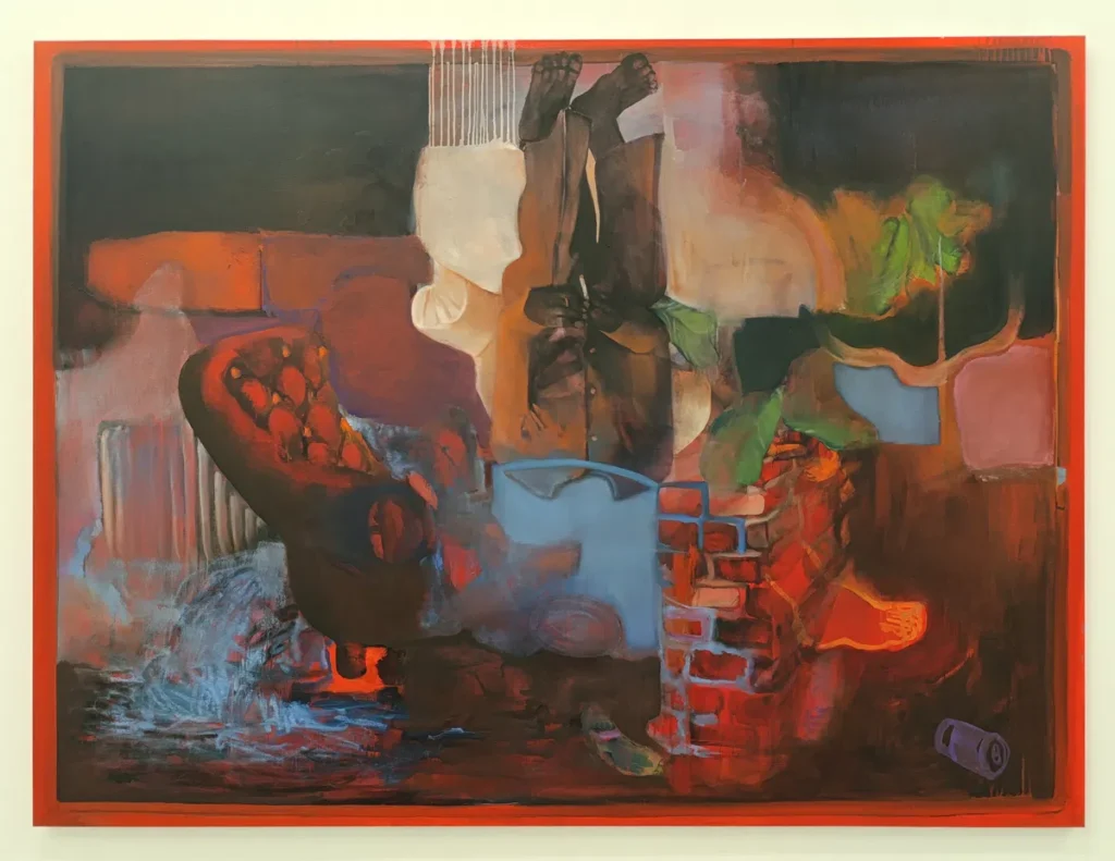 Photo d'une peinture encadrée, dominée par des tons rouges, bruns, verts et bleus. La composition montre un intérieur fragmenté : à gauche, un fauteuil capitonné sombre posé sur un sol aux traces de peinture. Au centre, une forme verticale évoquant un corps humain inversé : des jambes et des pieds sont visibles vers le haut de la toile, tandis que le reste du corps se confond avec des aplats de couleur. À droite, un mur de briques rouges partiellement visible, un pot ou récipient bleu au premier plan, et une plante verte aux feuilles larges. En bas à droite, un objet cylindrique gris est posé sur le sol. L’ensemble est entouré d’un large cadre peint en orange.