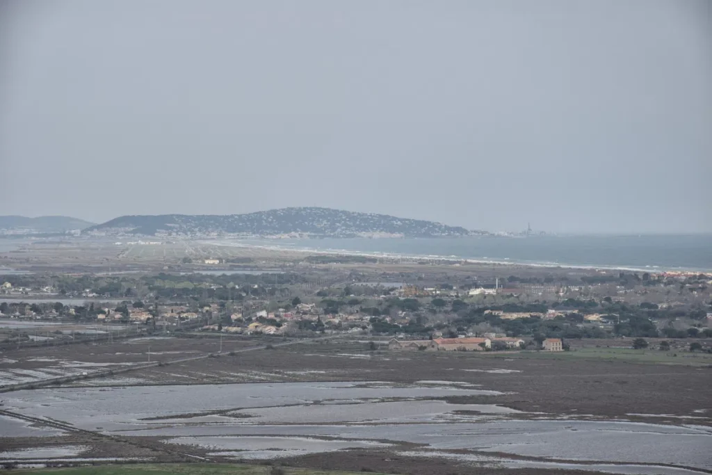 Photo prise des hauteurs. Des étangs, la Méditerranée, et le Mont Saint-Clair au loin.