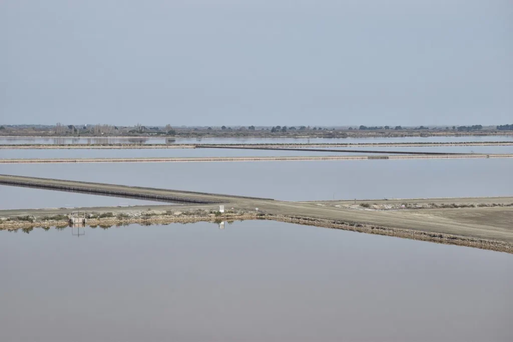 Photo de marais salants sous un ciel légèrement voilé.
