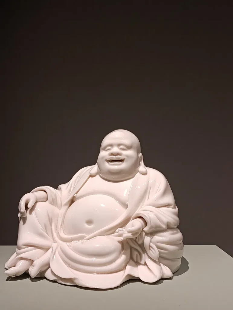 Photo d'une petite statue de Budai en porcelaine.
