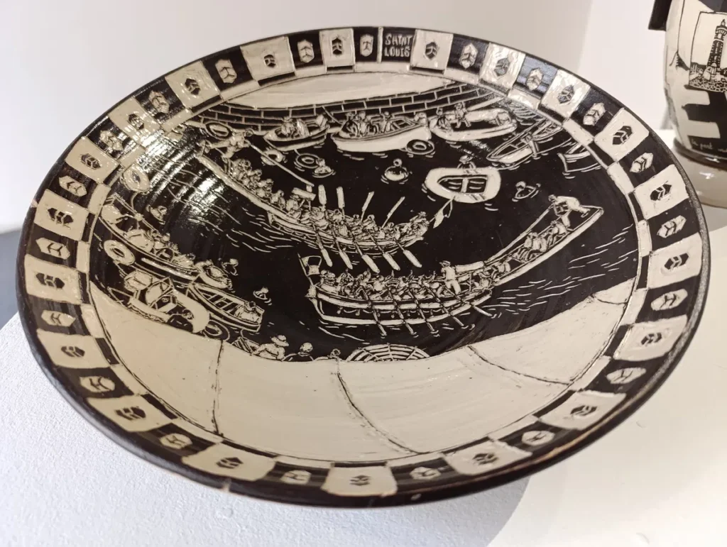 Ce qui ressemble à une ancienne poterie grecque, monochrome, avec, représentée, une scène de joutes sétoises.